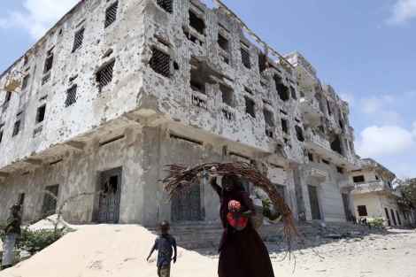 Una mujer somal camina con su hijo por una calle desierta en Mogadiscio.| Reuters