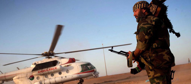 Un rebelde libio camina hacia un helicptero ambulancia en un camino cerca a Sirte. | Efe