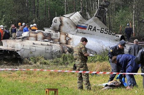 Un grupo forense, junto a una de las vctimas del accidente del Tupolev en Rusia. | Ap