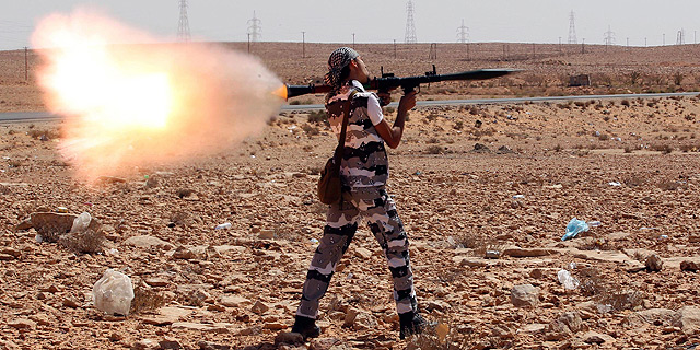 Un rebelde libio dispara un lanzacohetes contra las fuerzas leales a Gadafi en Bani Walid, al sur de Trpoli. | Efe