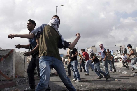 Palestinos lanzan piedras a soldados israeles en Kalandia.| Efe