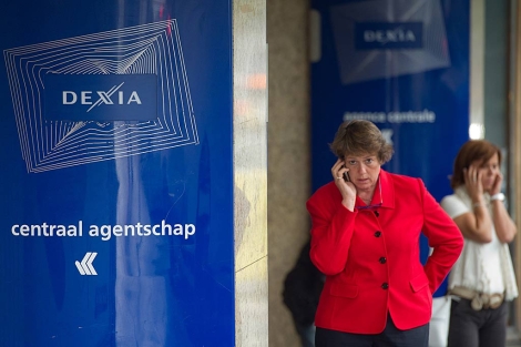 Trabajadores del banco franco-belga Dexia hablan por telfono a las puertas de la sede de la entidad en Bruselas. | AP