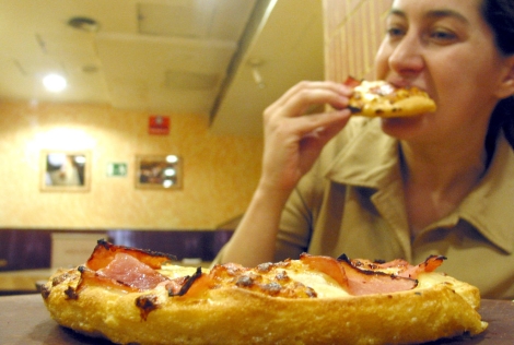 Mujer comiendo pizza en un restaurante | Antonio Heredia