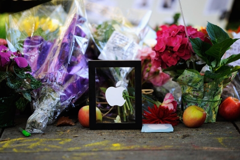 Manzanas, flores y velas ante la casa de Jobs. | AFP