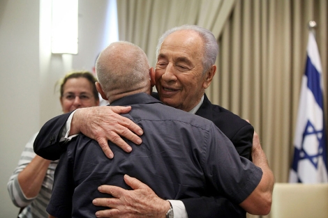 Simon Peres (de frente) recibe a los padres del soldado. | AFP