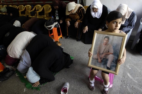 Una nia palestina con una imagen de un familiar preso en Israel. | Reuters