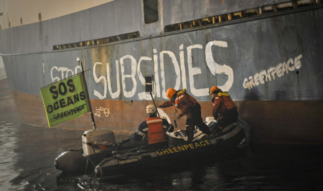Activistas de Greenpeace pintan un pesquero de arrastre de fondo en Vigo. | Pedro Armestre / Efe