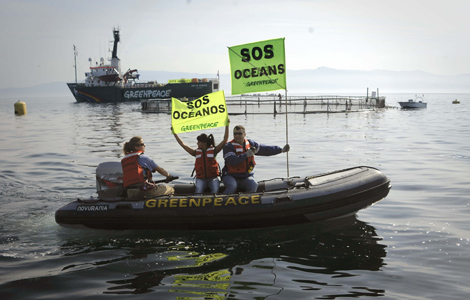 Protesta de Greenpeace contra una granja de salmones en la ra de Muros-Noia. | Pedro Armestre / Efe