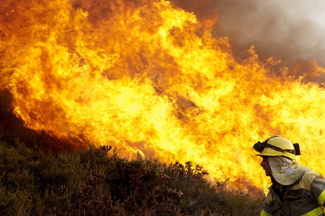 Un bombero lucha contra el fuego en la localidad ourensa de Santirso. | Efe