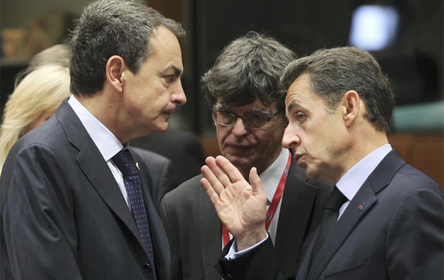 Zapatero escucha a Sarkozy durante la cumbre europea. | Reuters