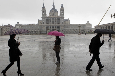 Una personas pasan por la plaza del Palacio Real de Madrid. | Sergio Barrenechea / Efe