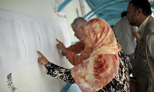 Una mujer mira en las listas su mesa para ejercer su derecho al voto en Túnez. | Efe