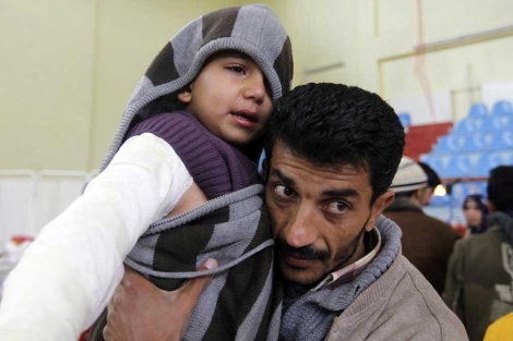 Un hombre sostiene a su hijo en brazo, en un refugio en Ercis.| Reuters
