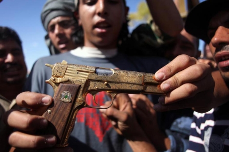 Rebeldes libios exhiben la pistola de oro de Gadafi tras su captura y asesinato. | MANU BRABO