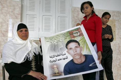 La madre y las hermanas de Mohamed Bouazizi, con un cartel en su honor. | Reuters