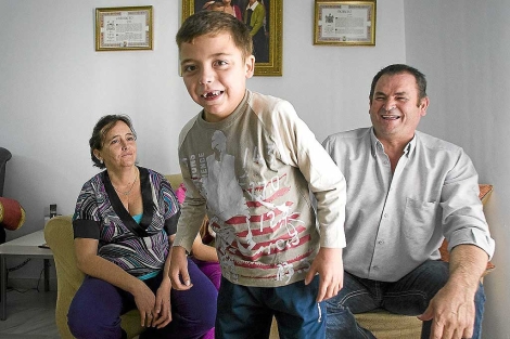 Un sonriente y mellado Marcos Carribero, en su casa, junto a sus padres. | Jos F. Ferrer
