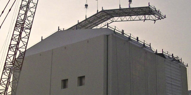 Una gra instala paneles en la cubierta del reactor nmero 1 de la planta de Fukushima. | Efe