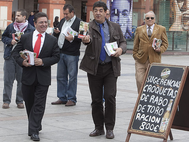Valderas repartiendo panfletos junto al anuncio del men de un restaurante. | M. Cubero