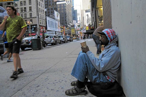 Un afroamericano mendiga en una calle de Broadway. | AP