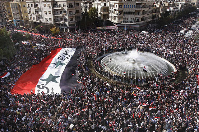Manifestantes favorables al rgimen de Asad despliegan una bandera gigante en Damasco. | Ap