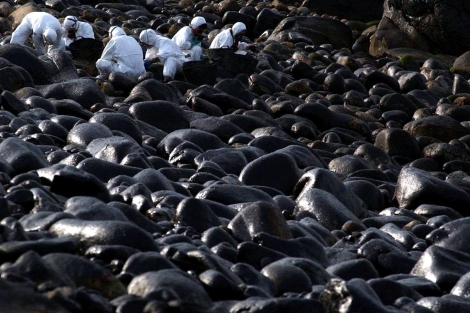 Piedras negras por el vertido en la playa de Muxa, en febrero de 2003. | Reuters