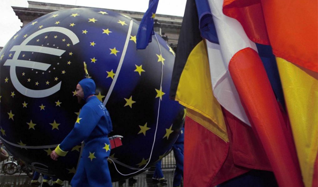 Varias banderas de la Eurozona junto al smbolo del euro. | Ap