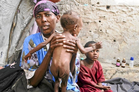 Una mujer sostiene a su hijo en un centro de distribucin de urgencia en Somalia. | Efe