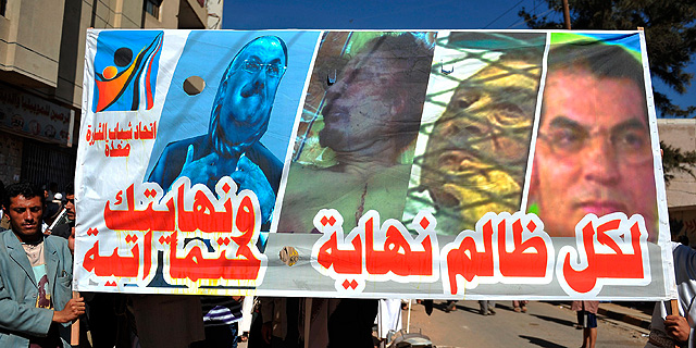 Manifestantes yemenes muestran un cartel con los cuatro dictadores derrocados: Saleh, Gadafi, Mubarak y Ben Ali. | AFP