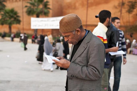 Un marroqu lee un planfleto del movimiento 20 de Febrero en Rabat. | Efe