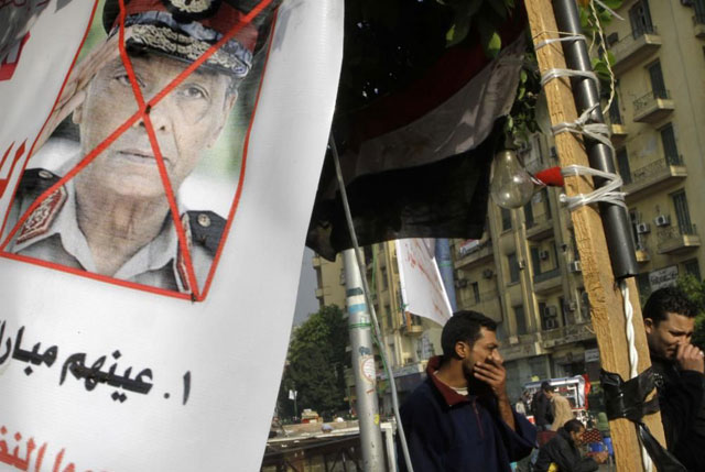 Manifestantes egipcios protestan junto a un cartel que tacha el rostro de Tantaui. | Ap