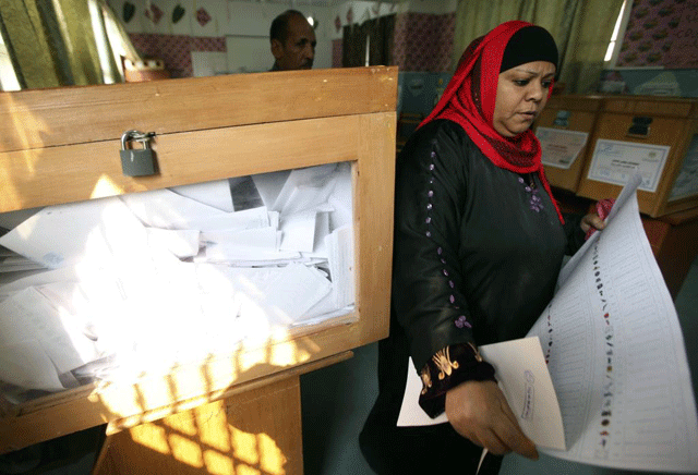 Una mujer egipcia con la papeleta para votar en un colegio electoral de El Cairo. | Reuters
