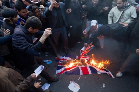 Varios jvenes queman una bandera de la embajada britnica. | Reuters