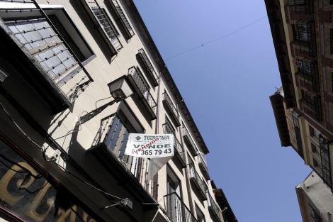 Cartel de 'Se vende' con la sobreimpresin de 'Vendido', en Madrid. | Bernardo Daz