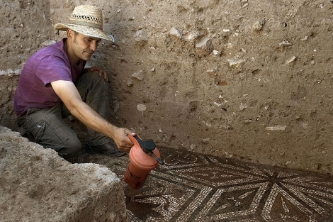 Un miembro del equipo de arquelogos trabaja en un mosaico. | Efe