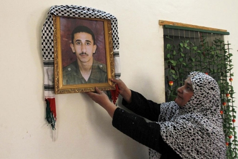La madre de uno de los presos que serán liberados muestra su foto.| Reuters