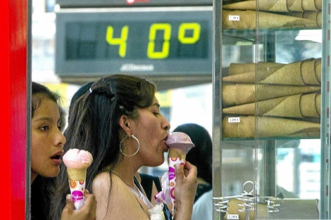 Dos chicas con un helado junto a un termmetro que marca 40 grados en Bilbao. | I. Andrs