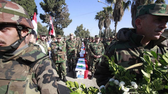 Soldados sirios asisten al funeral de compaeros fallecidos en la provincia de Homs (Siria). | Efe