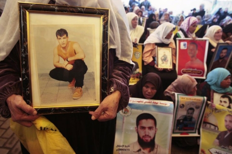 Palestinos muestran imágenes de varios presos durante una protesta en Gaza. | Reuters