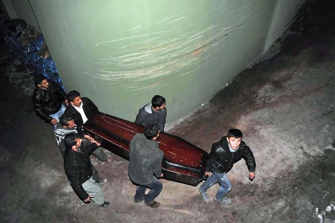 Varios kurdos trasladan uno de los fretros de los muertos en el ataque turco.| Ap