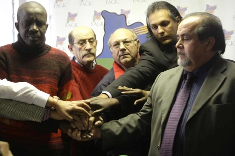 Representantes de asociaciones gitanas y senegalesas se dan la mano. | Reuters