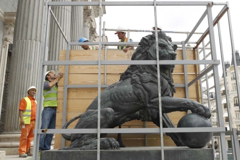 Operarios protegen los leones de la puerta del Congreso de los Diputados durante unas obras en 2010. | Sergio González