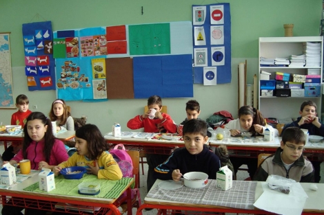 Un grupo de nios come en un colegio griego.