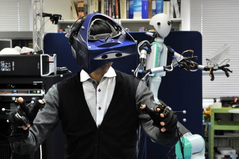 El robot y la persona que lo maneja a distancia con un casco de realidad virtual. | AFP