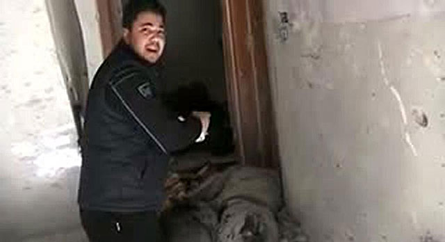 Un vecino del barrio de Bab Amro, en Homs, muestra supuestamente el cadver de un periodista. | Afp
