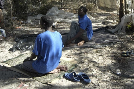 Dos inmigrantes africanos rezan conforme a la tradicin musulmana en una finca de Lepe. | J. Yez