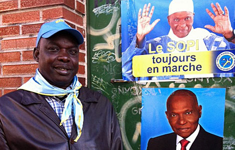 Telle Diene, seguidor del presidente Wade, posa con carteles electorales. | A. F.