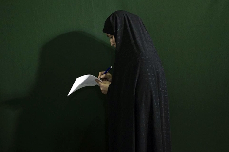 Una mujer prepara su voto. | Reuters
