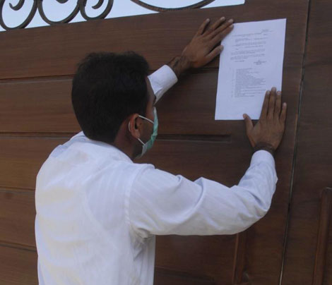 Un funcionario pega la citacin en la residencia que Musharraf tiene en Islamabad. | Efe