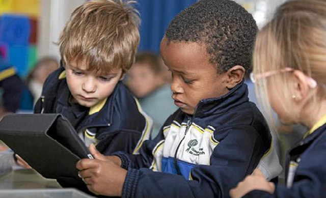 Tres nios trabajan con un iPad en el colegio Ausis March. | E.M.