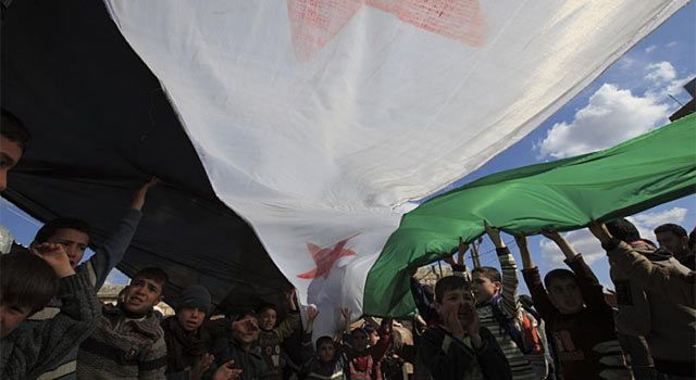 Un grupo de niños sostiene una bandera independentista siria. | Reuters